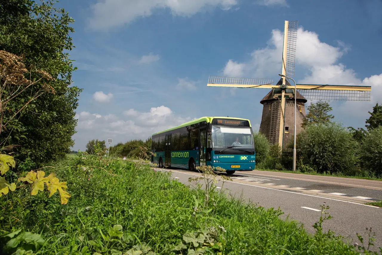 foto van connexxion bus in landelijk gebied met molen