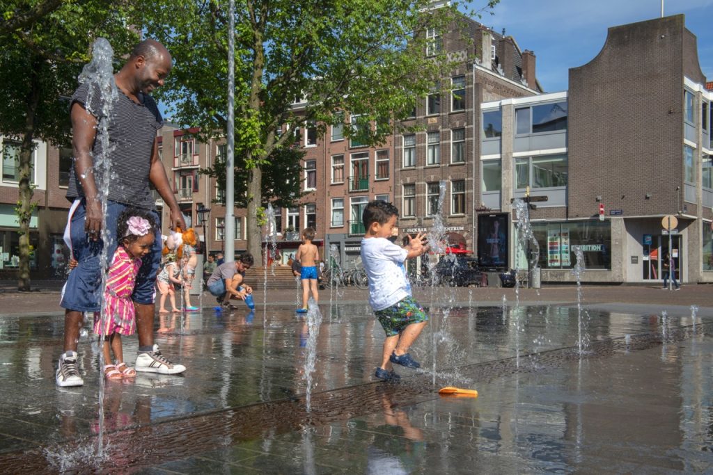 Spelende kinderen bij fontein in de stad